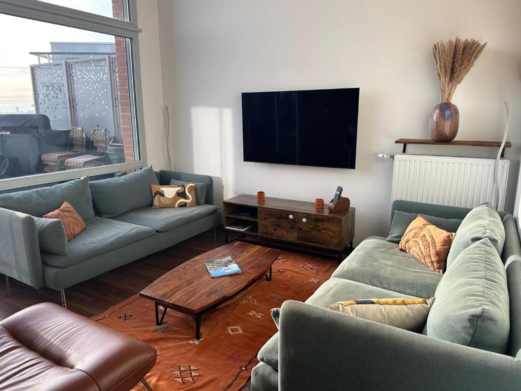 un salon avec deux canapés et une télévision à écran plat dans l'établissement Duplex cosy proche de Paris, à Bezons