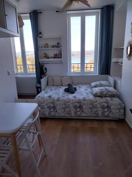 une chambre avec un lit sur lequel est allongé un chat dans l'établissement Élégance au Bord de l'Eau, à Aiguebelette-le-Lac