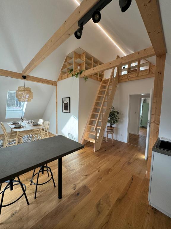 a loft conversion with a staircase and a dining room at Stadtblick Passau Apartment in Passau