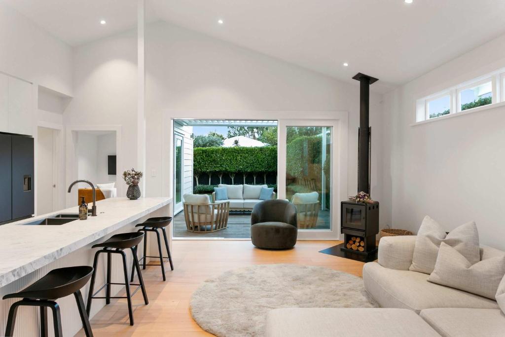 a kitchen and living room with a couch and a table at Luxury Central Villa with Spa Pool Prime Location in Auckland