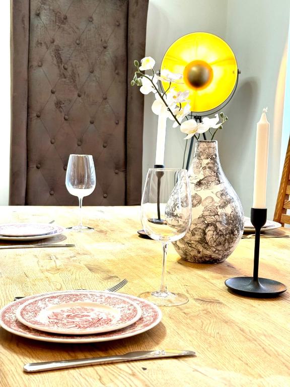 a wooden table with plates and glasses and a candle at Belvedere Apartment in Vienna