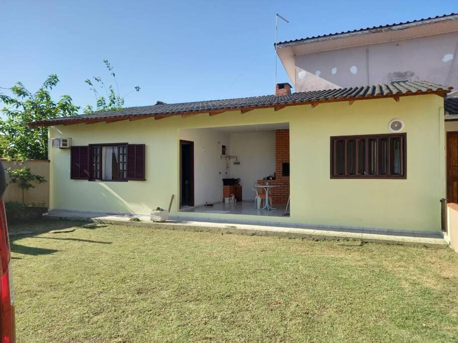 a house with a yard in front of it at Simplesmente aconchegante in Itapoa