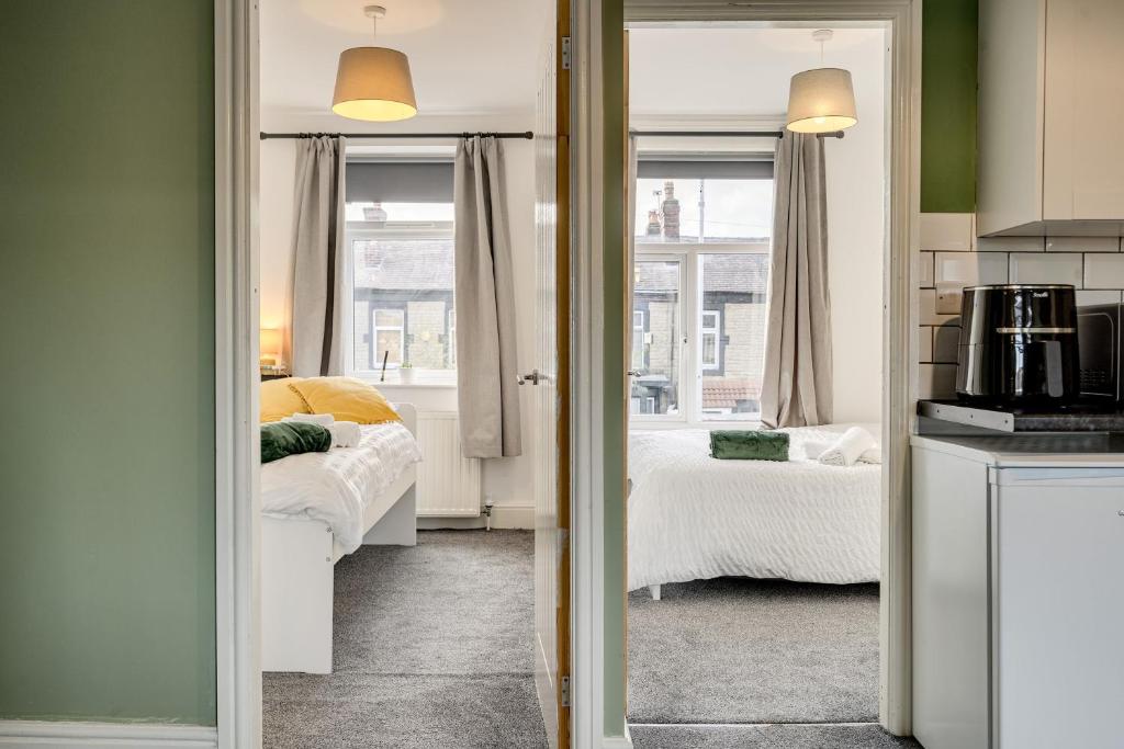 a room with two beds and a kitchen with a kitchen at The Old Bike Shop Flat 2 in Heapey