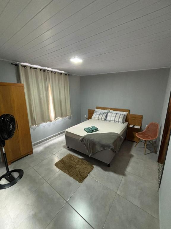 a bedroom with a bed and a desk and a chair at Pousada Vista das Pedras in Pancas