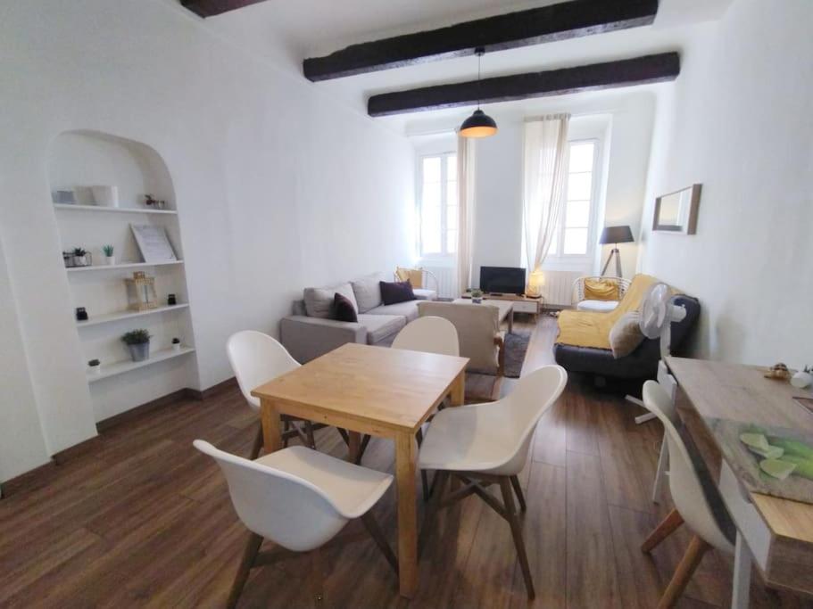 un salon avec une table, des chaises et un canapé dans l'établissement Sur le Vieux Port , Appartement 50m2, 4pers, à Marseille