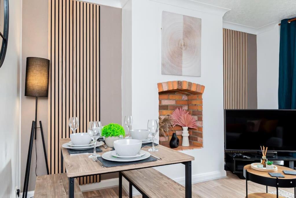 a dining room with a table and a fireplace at Enchanting 4 spacious bedrooms in Birmingham
