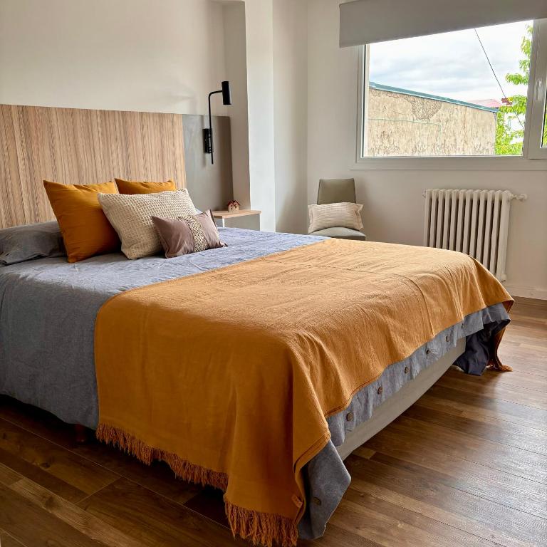 a bedroom with a large bed with an orange blanket at Aiila House in Esquel