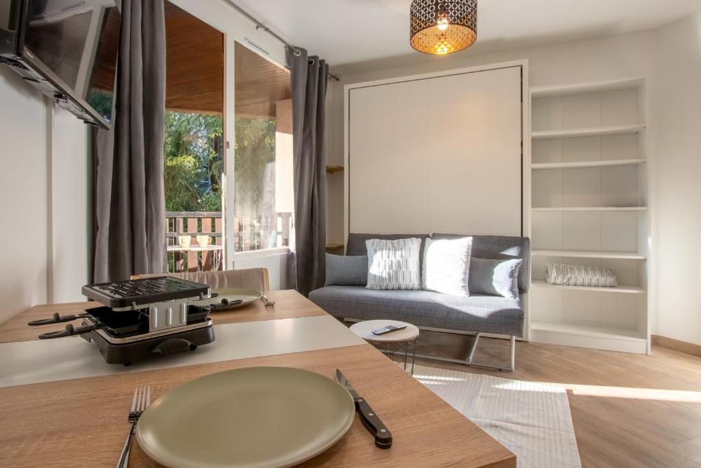 un salon avec une table et un canapé dans l'établissement Lachenal - Centre - Navette de ski - Balcon, à Chamonix-Mont-Blanc