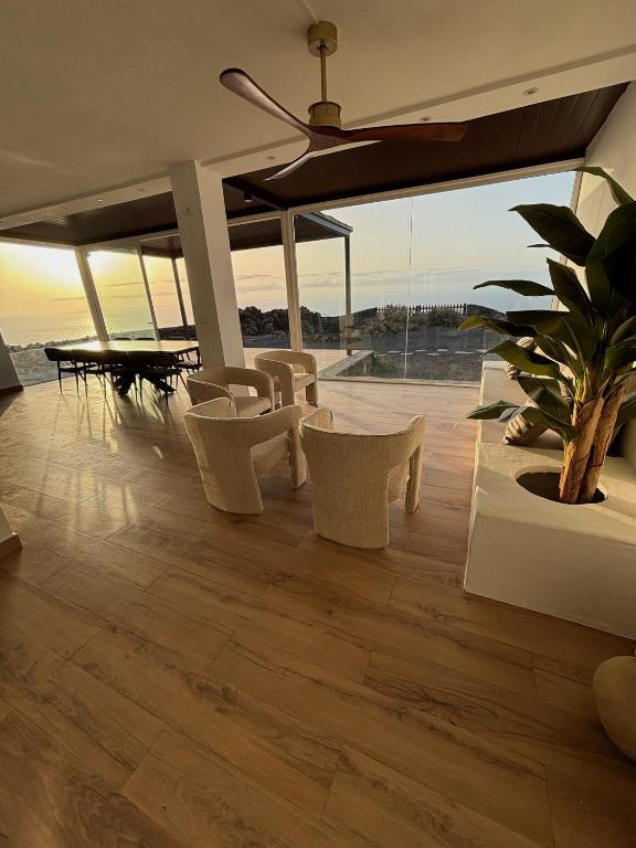 a living room with chairs and a table with a plant at Villa Olimonte in Valverde