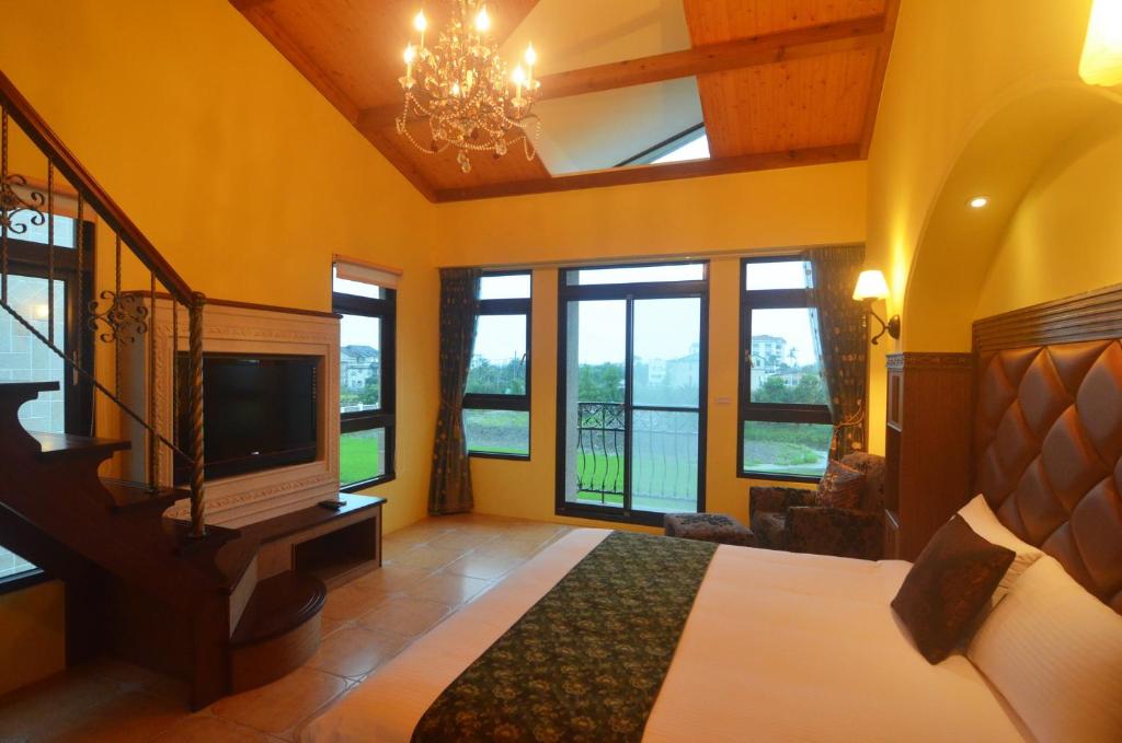 a bedroom with a bed and a tv and windows at Full Sweet Inn in Wujie