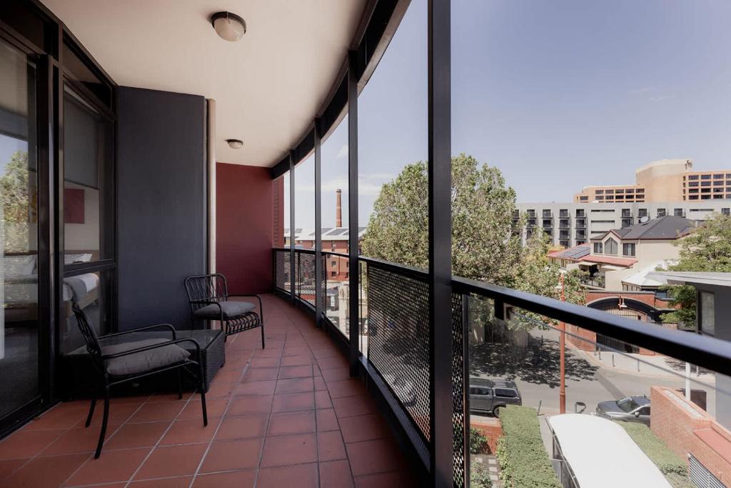 a balcony with chairs and a view of a city at Inner-city 2 bedroom apartment - perfectly located in Hobart