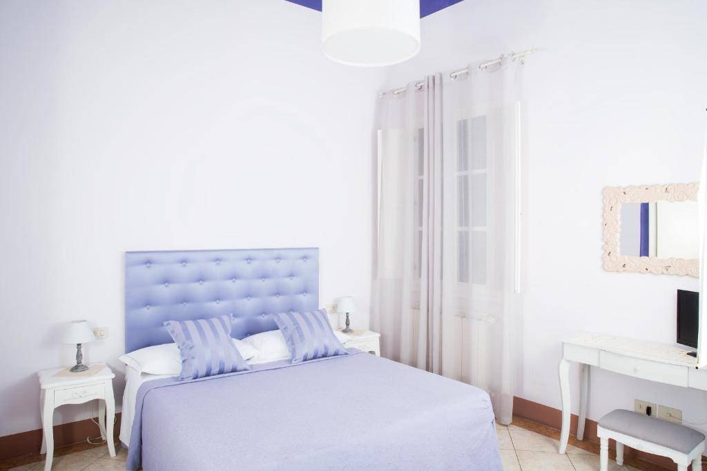 a bedroom with a white bedspread and a blue comforter at B&Beatrice in Florence