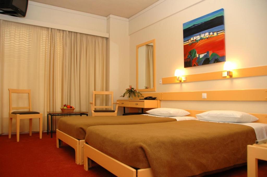 una camera d'albergo con 2 letti e una scrivania di Amalia a Salonicco