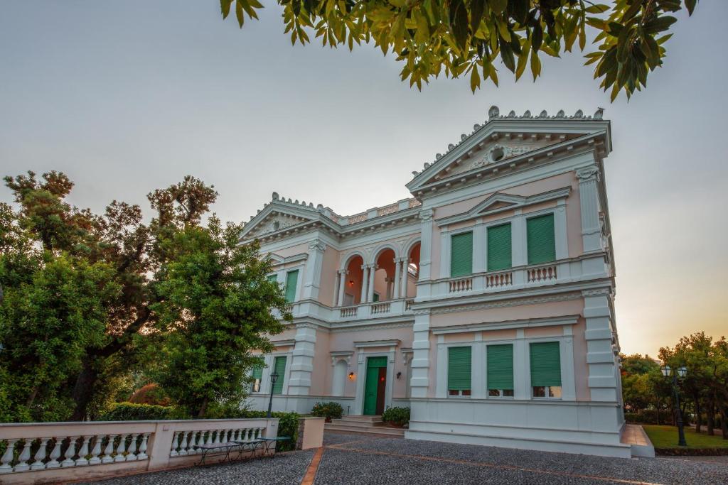 a large white building with green windows at Villa Irlanda Grand Hotel in Gaeta