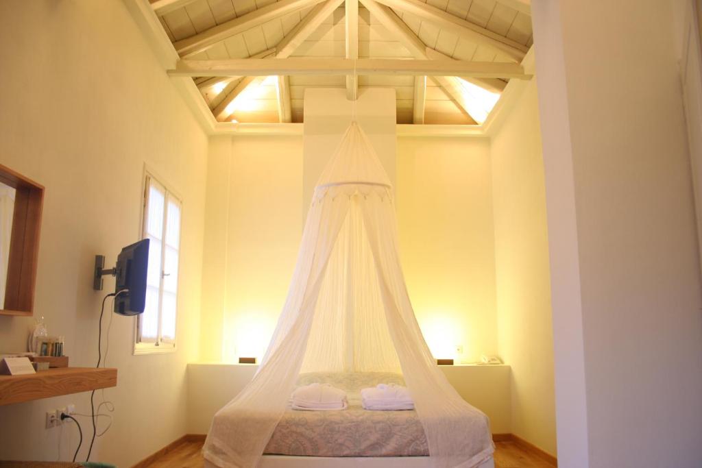 a bedroom with a bed with a white canopy at Xenon Estate in Spetses