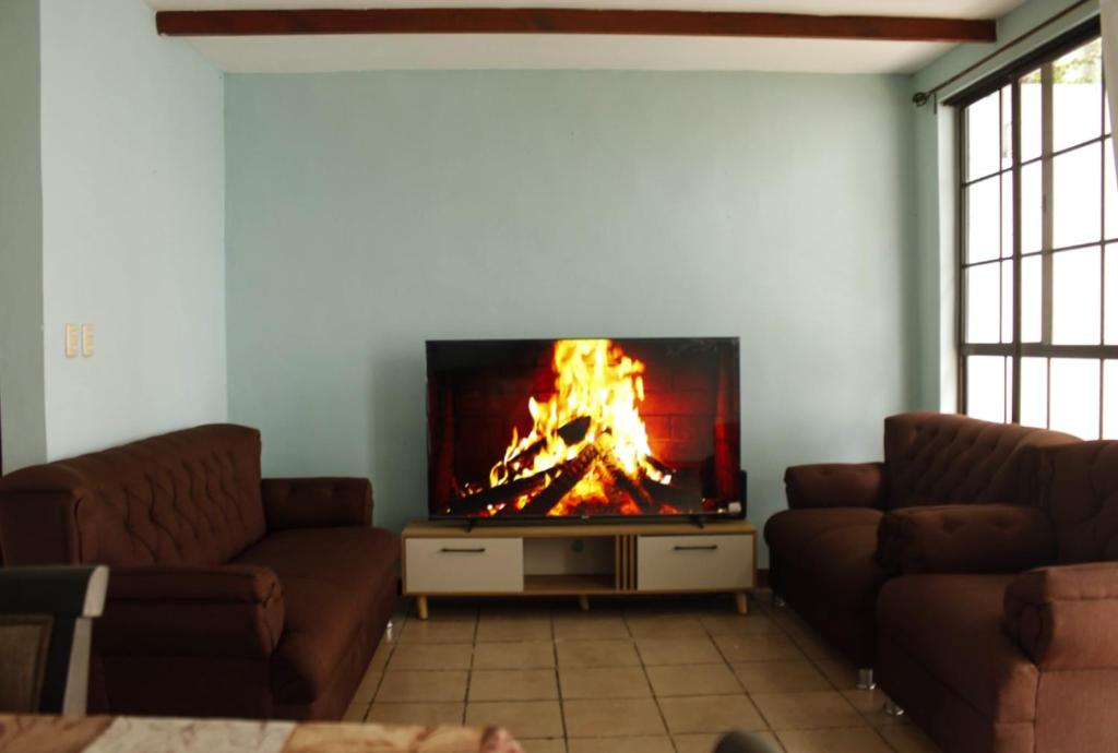 a living room with a fire in the fireplace at casa en la Cima in San Salvador
