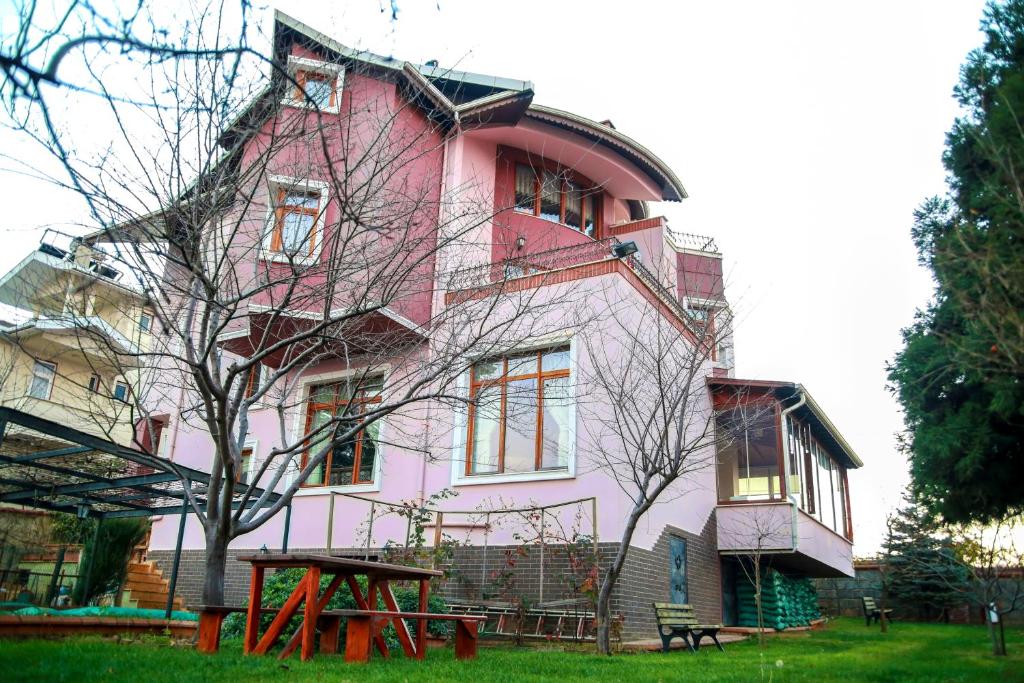a pink building with a picnic table in front of it at Family Seaview Villa 1 in Trabzon