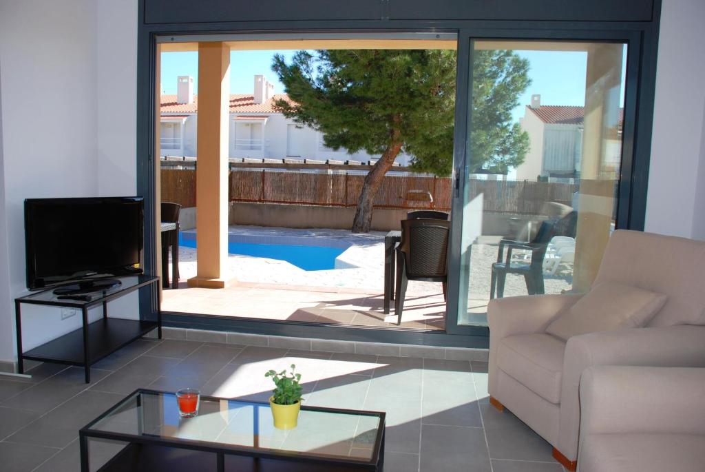 a living room with a couch and a glass table at Villa Marina del Port 1 in L'Ametlla de Mar
