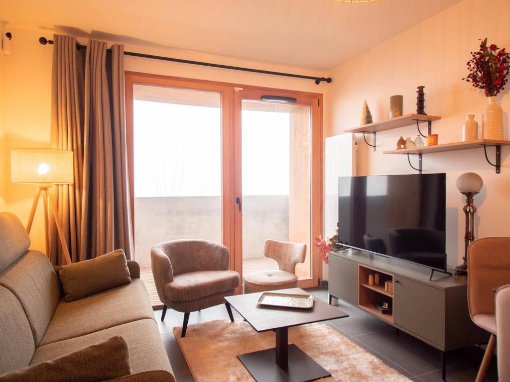 ein Wohnzimmer mit Couch und Flachbildfernseher in der Unterkunft Charmant T2 à Valmorel avec parking et casier à ski - FR-1-291-1016 in Valmorel