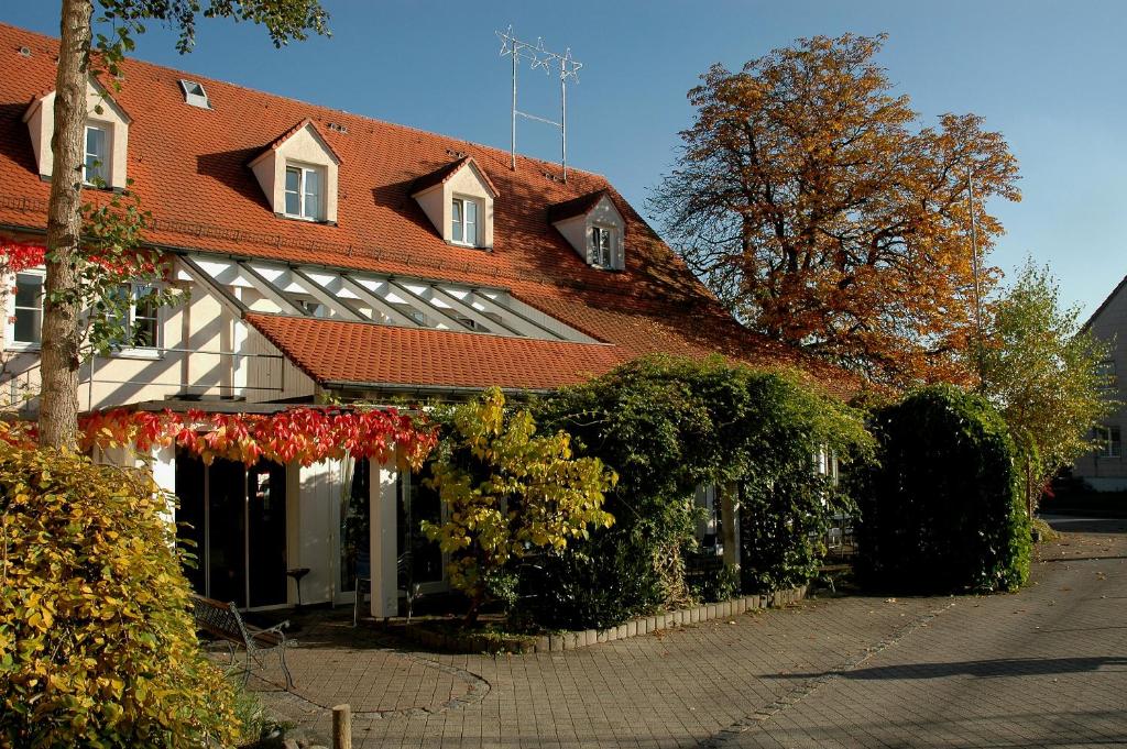 een groot gebouw met een rood dak en een aantal struiken bij Hotel Engel in Ulm