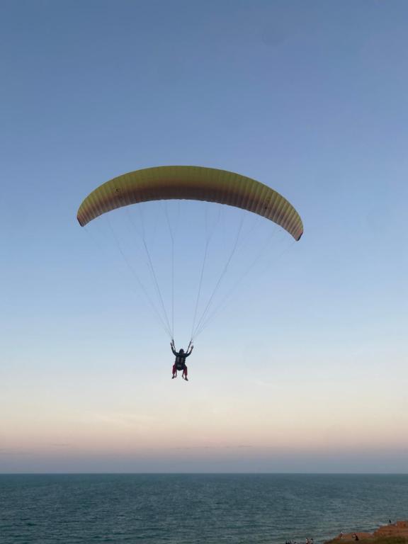 Una persona che vola un paracadute sull'oceano di Portal do Sol a Canoa Quebrada