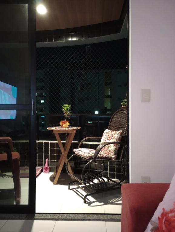 a patio with two chairs and a table on a balcony at Quarto Simples em Apto Charmoso in Maceió