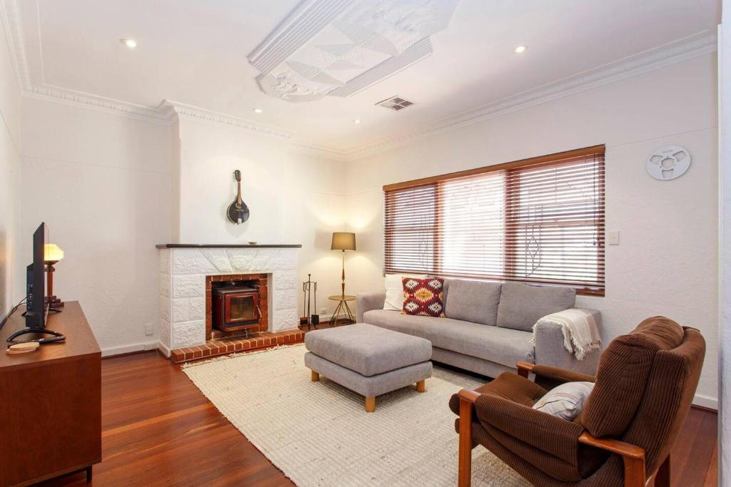 ein Wohnzimmer mit Couch und Kamin in der Unterkunft Directors Cottage Fabulous Local & Peaceful in Fremantle