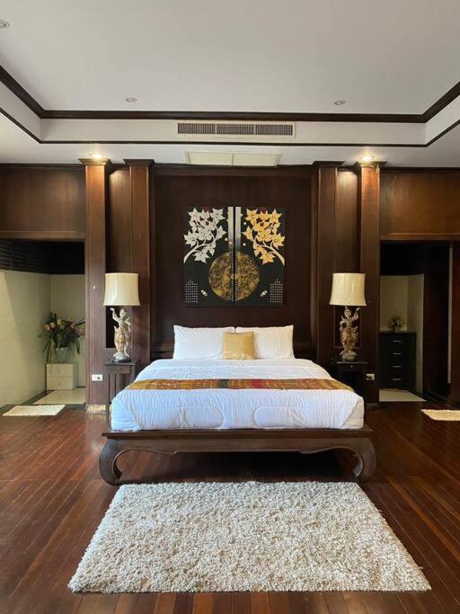 a bedroom with a large bed and two lamps at Vela House Phuket in Changwat Phuket