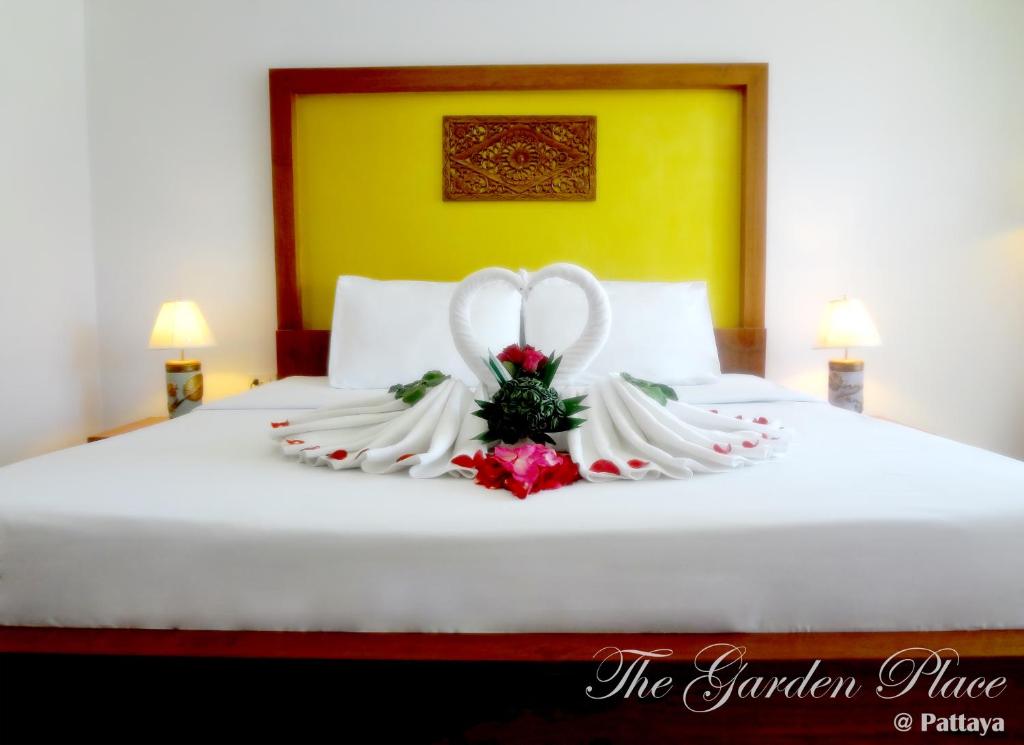 Un ramo de novia y novio en una cama en The Garden Place Pattaya en Pattaya centro