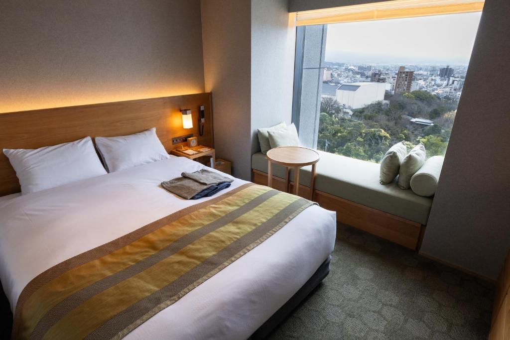 pokój hotelowy z dużym łóżkiem i oknem w obiekcie Fujisan Mishima Tokyu Hotel w mieście Mishima