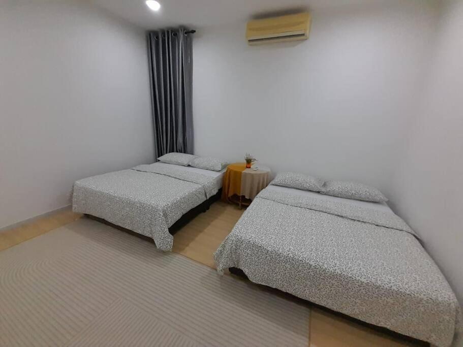 a room with two twin beds and a table at Crystal Heights Cozy House in Tupai