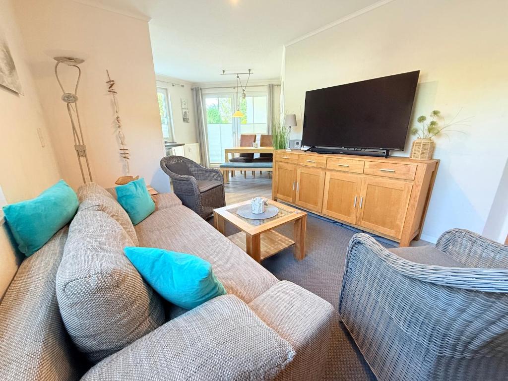 un soggiorno con divano e TV a schermo piatto di Residenz am Yachthafen, Whg 8 a Grömitz