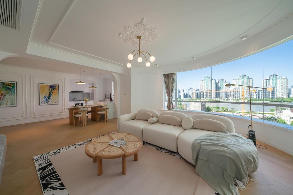 Hotel Eastern Hub - Bund Branch Simply Luxurious 4 King Beds, Big French Windows with Bund Views, a living room with a couch and a table at Eastern Hub - Bund Branch Simply Luxurious 4 King Beds, Big French Windows with Bund Views in Shanghai