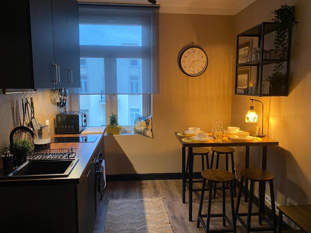 a kitchen with a table and two stools in it at Polonia Apartments No-68 Near Piotrkowska in Łódź