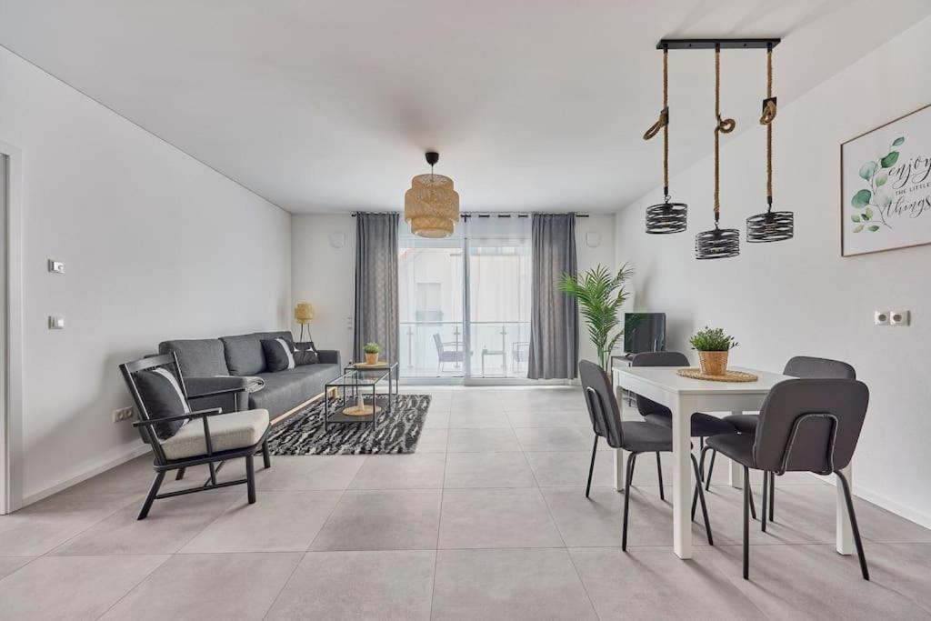 a living room with a couch and a table and chairs at Zentral und ruhig Netflix Balkon Parkplatz in Bruchsal