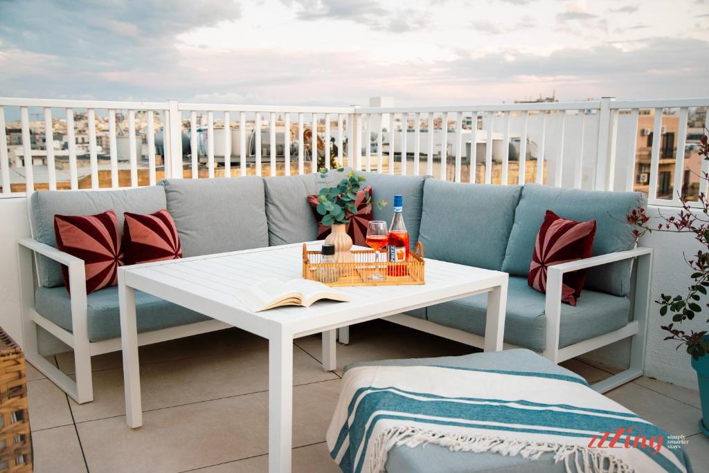 a couch and a table on a balcony at Spinola Stays in St. Julianʼs