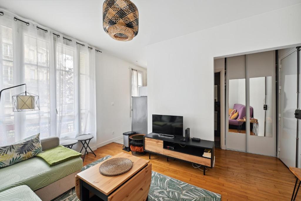 un salon avec un canapé et une télévision dans l'établissement Le Studaunien - Studio à 7min de Paris, à Saint-Ouen
