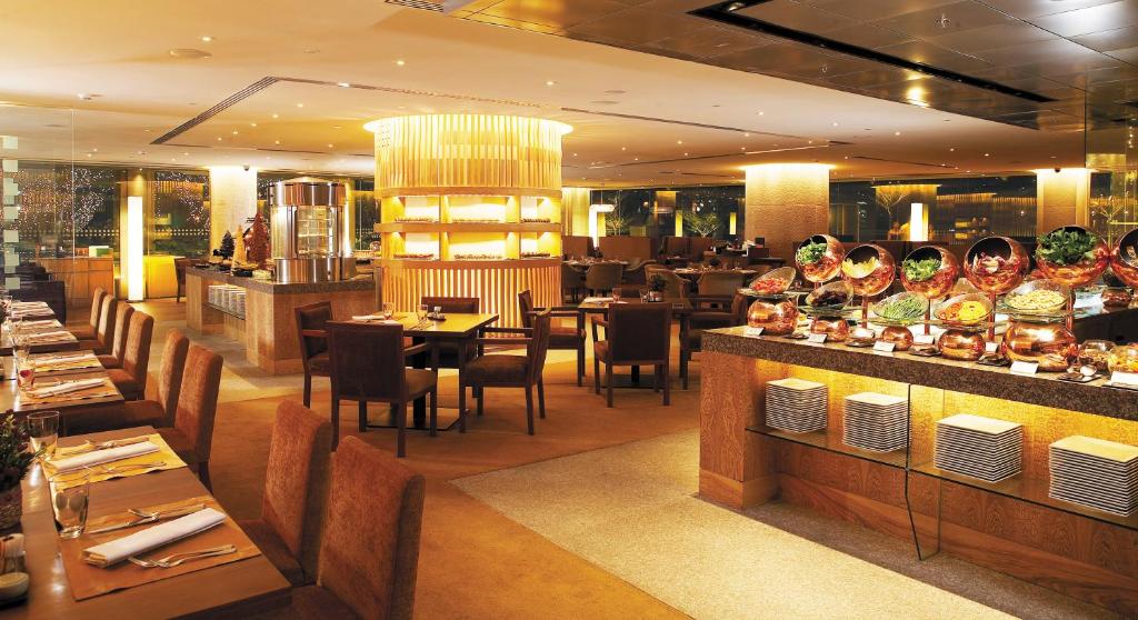 A warmly lit buffet restaurant with plated tables and a central service island.