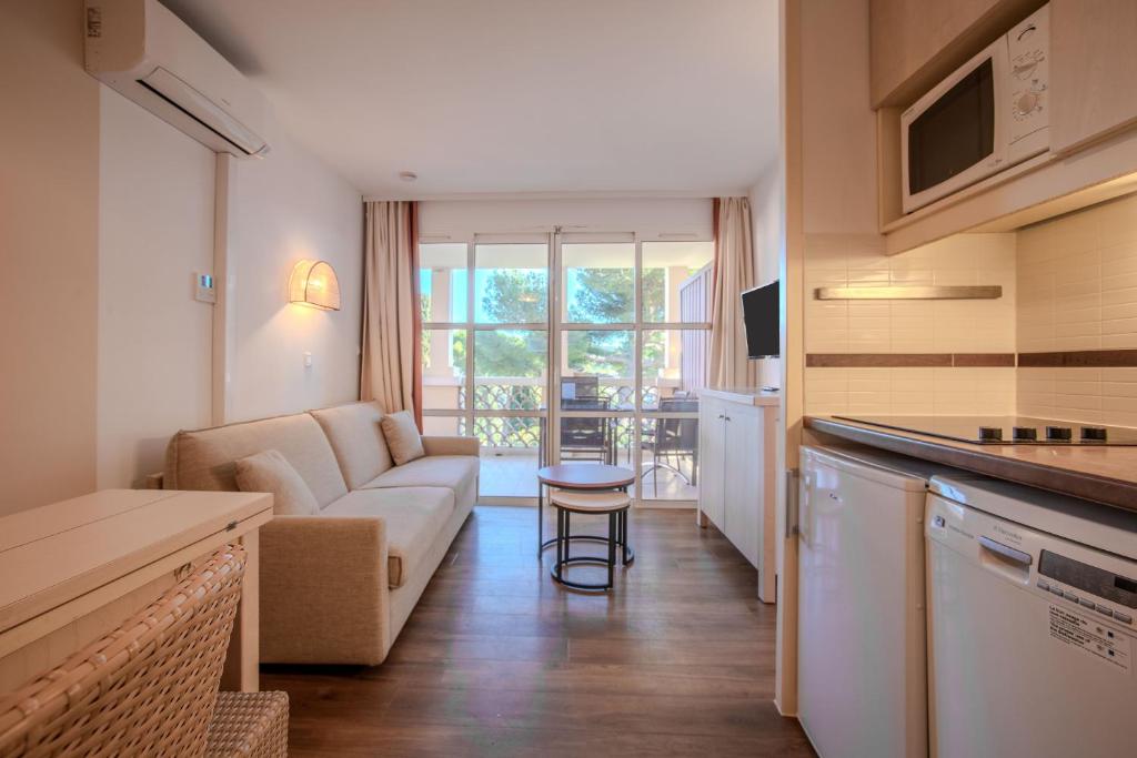 サン・ラファエルにあるAppartement Cap Esterelのソファとテーブルのあるキッチンとリビングルーム