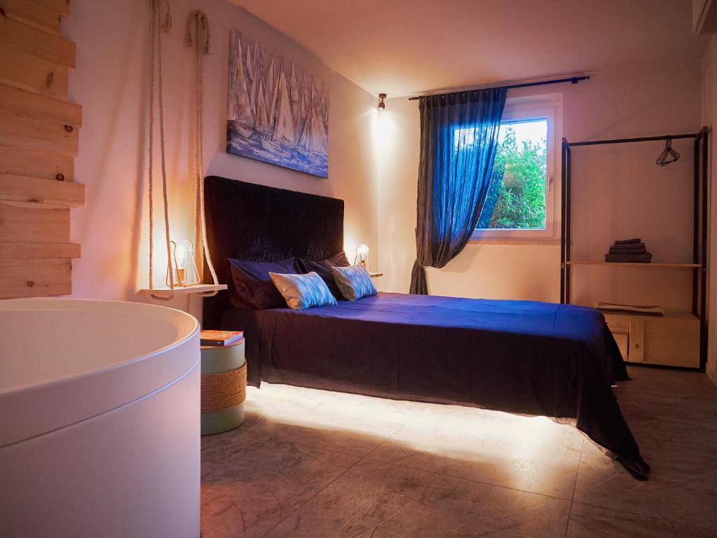 a bedroom with a bed with blue sheets and a window at RedHouse Benaco in Torri del Benaco