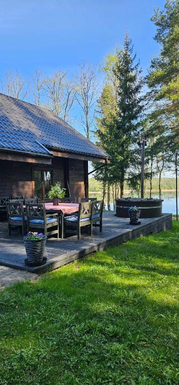 a patio with a table and chairs and a house at Asvejos sodyba in Skirlėnai