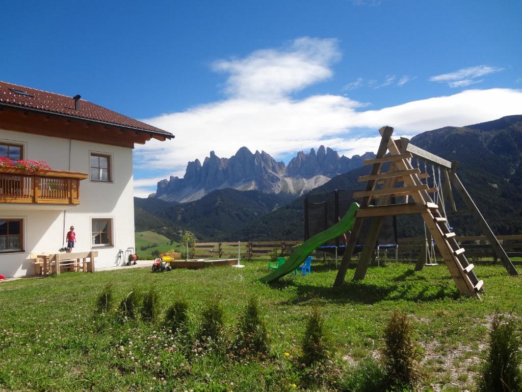 a playground in a field with mountains in the background at Ritzhof in Funes