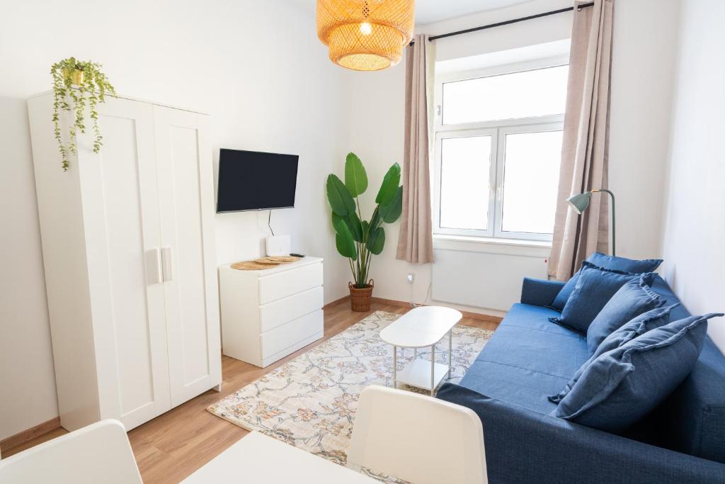 un salon avec un canapé bleu et une télévision dans l'établissement Vienna City Apartments 1110 Vienna, à Vienne