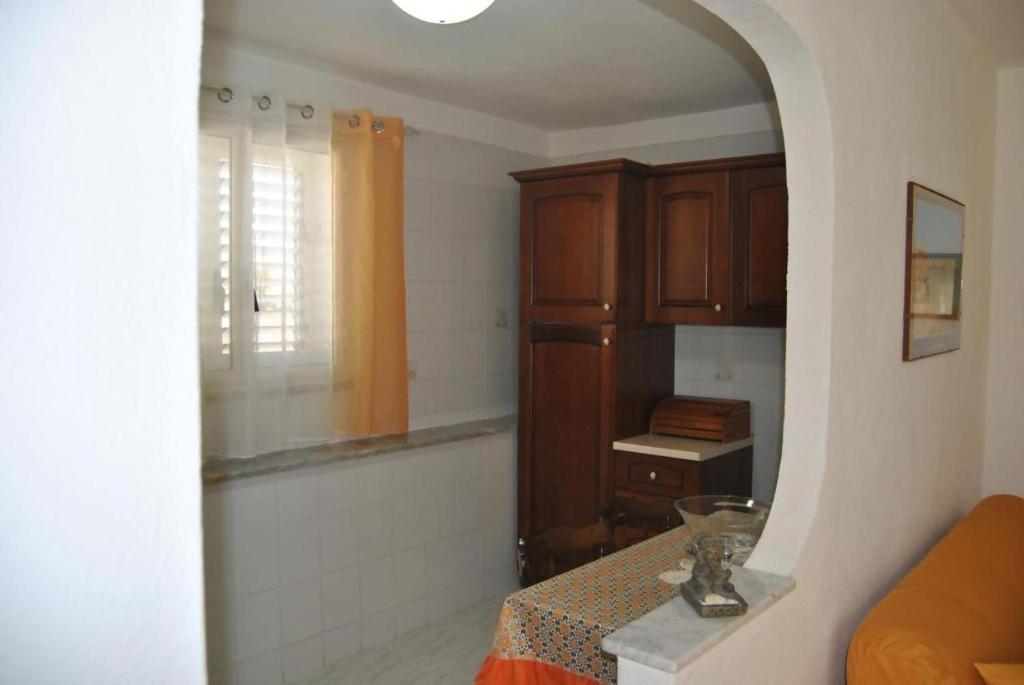 a living room with a table and a window at La Pergola Apartments in Lampedusa
