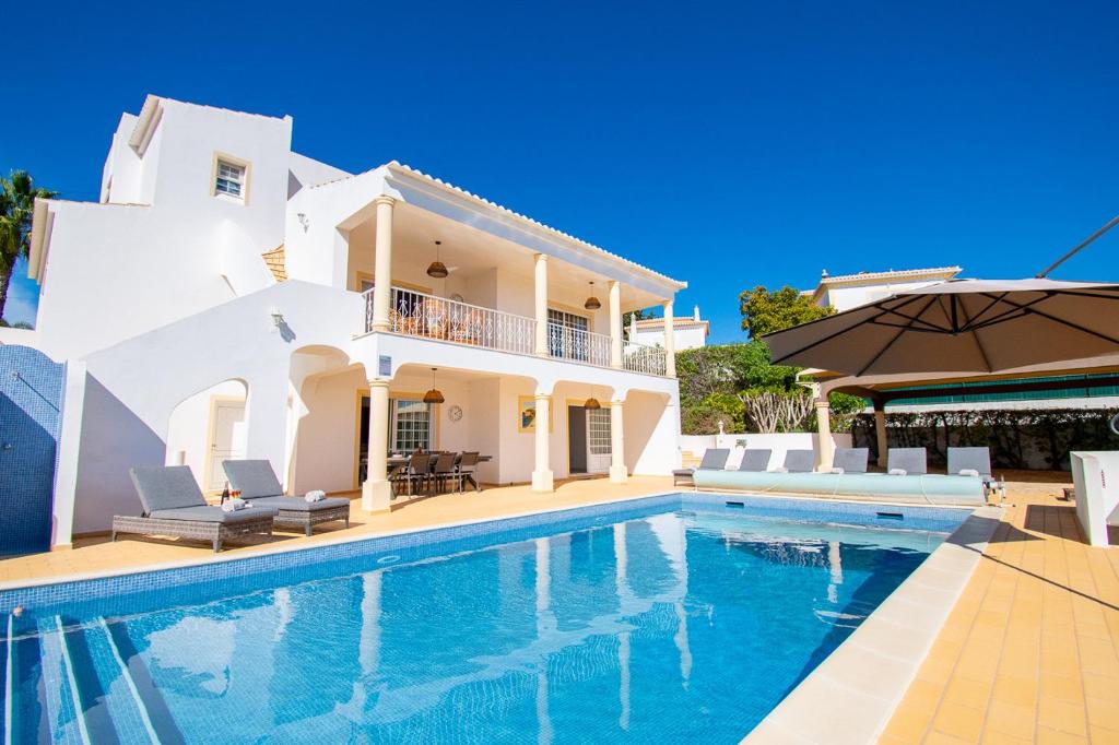 a villa with a swimming pool and a house at Casa Filipa Full house - Spacious Villa with Private Pool & Jacuzzi in Praia do Carvoeiro