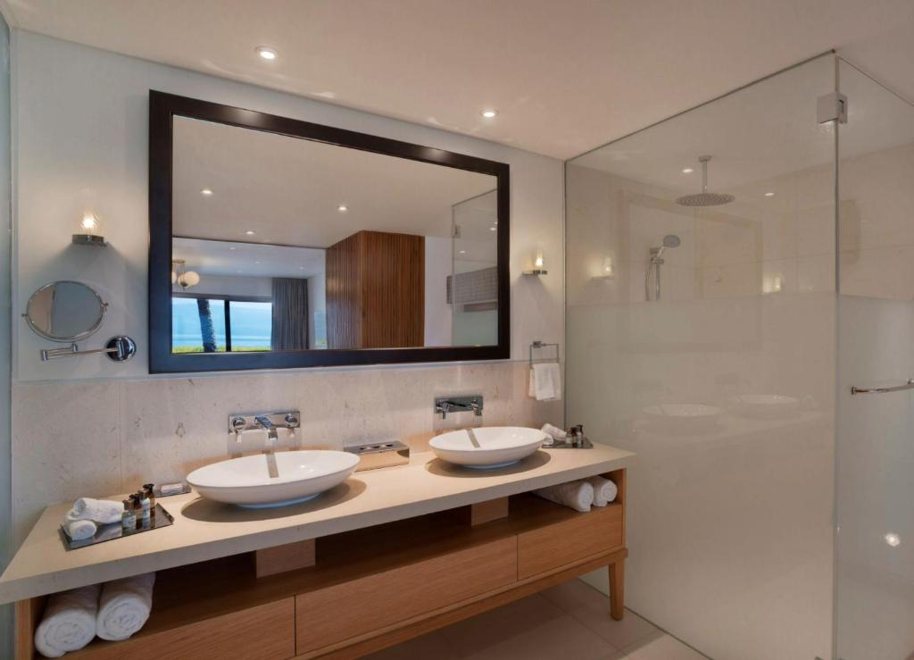 a bathroom with two sinks and a large mirror at The Setai Sea Of Galilee in Ein Gev