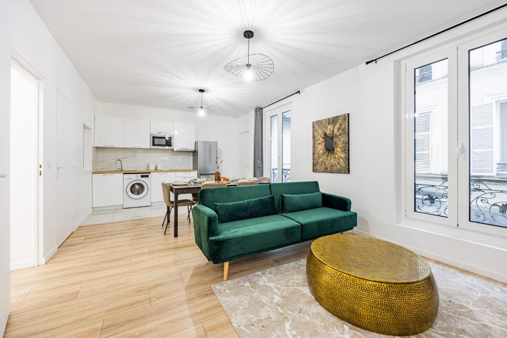een woonkamer met een groene bank en een tafel bij Nation Confort & Espace in Parijs