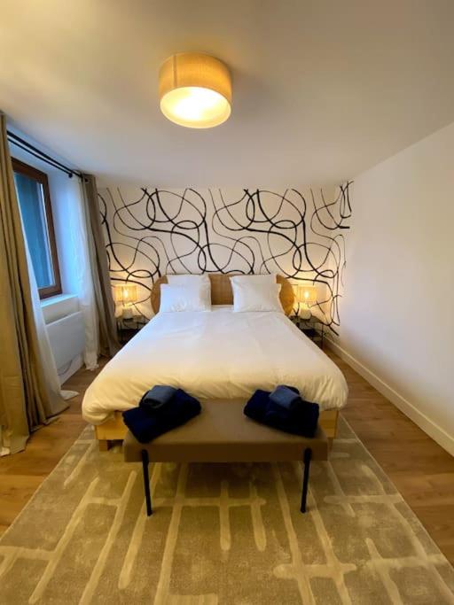 une chambre avec un lit avec un mur noir et blanc dans l'établissement Superbe T2 rénové 2km Gare avec parking privé, à Massy