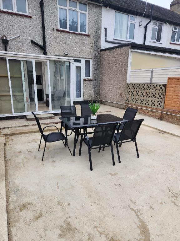 a patio with a table and chairs in front of a house at Time Space Bliss in Dagenham Dock