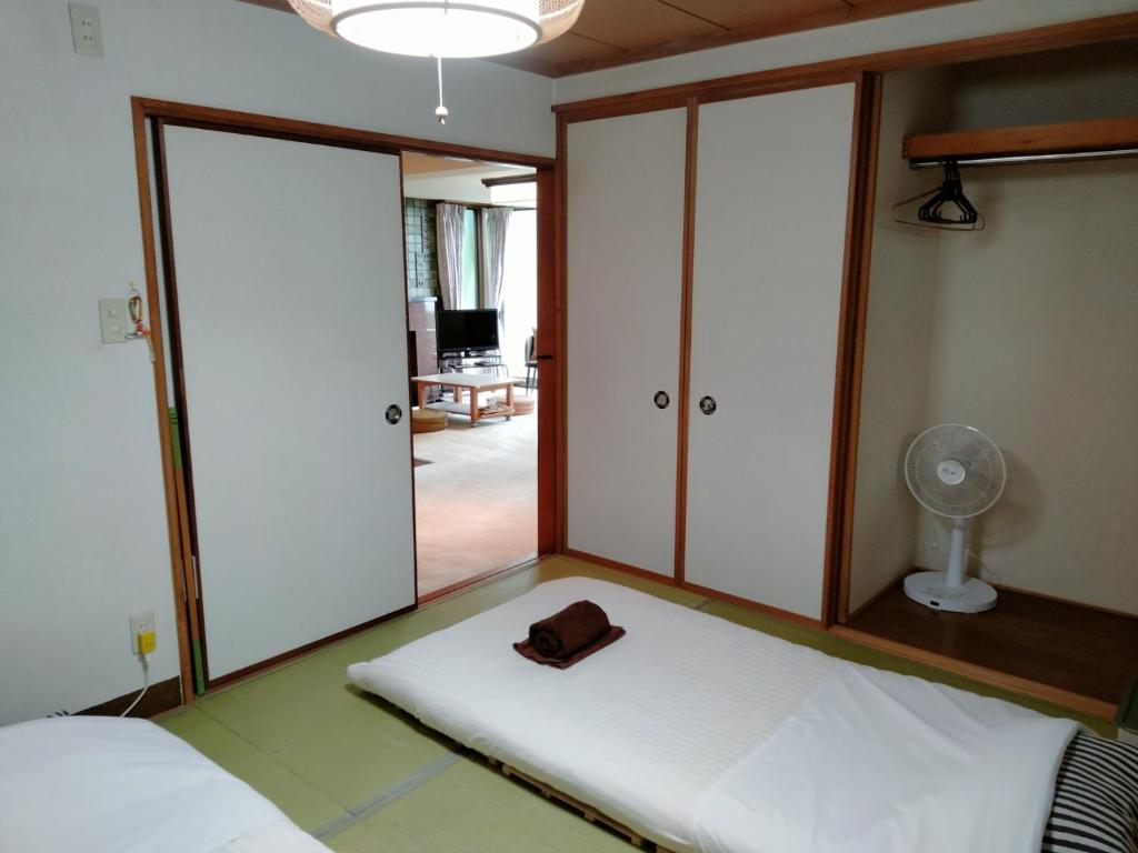 小樽市にあるBay View House - Vacation STAY 17471のベッド1台(帽子付)、ファンが備わる客室です。